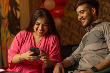 Friends using mobile phone while sitting at restaurant