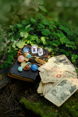 witch book with set of minerals, vintage divination cards in forest, natural background. Gemstones...