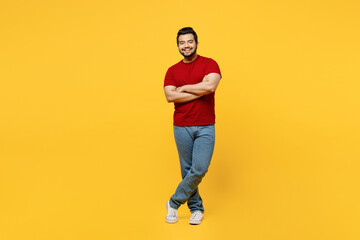 Fototapeta na wymiar Full body young smiling cheerful cool happy Indian man he wears red t-shirt casual clothes hold hands crossed folded look camera isolated on plain yellow orange background studio. Lifestyle concept.