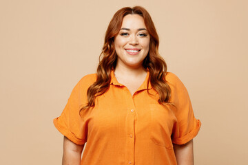 Young smiling happy satisfied fun cheerful chubby overweight woman she wear orange shirt casual...