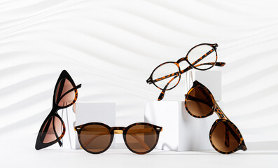 Sunglasses and glasses sale concept. Trendy sunglasses on podiums on white background. Trendy...