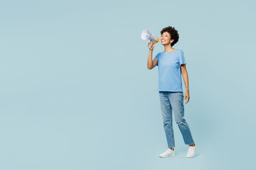 Full body young fun woman of African American ethnicity wear t-shirt casual clothes hold in hand megaphone scream announces discounts sale Hurry up isolated on plain pastel light blue cyan background.