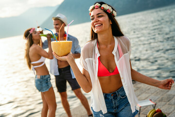 Group of friends having Hawaiian party on summer vacation. People fun travel concept.