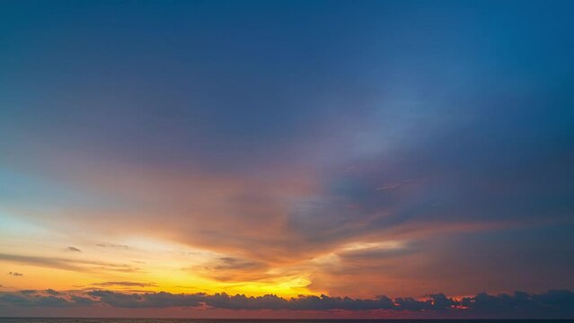 colorful light through to the cloud above the ocean..Clouds are moving slowly in stunning sunset video 4K. Nature video High quality footage .Scene of Colorful romantic sky sunset background.