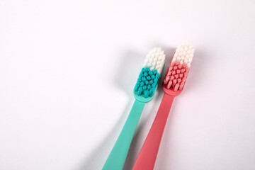 Pink and green toothbrush on a white background. Object, dental hygiene