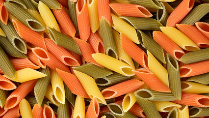Raw three coloured Italian pasta penne close up