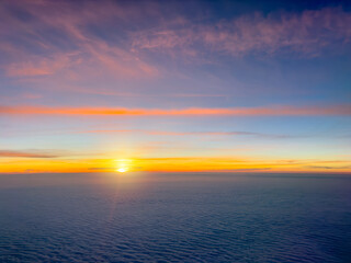 Sunrise seen from a airplane flying above the clouds
