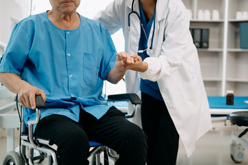 Asian physiotherapist helping elderly man patient stretching arm during exercise correct with...