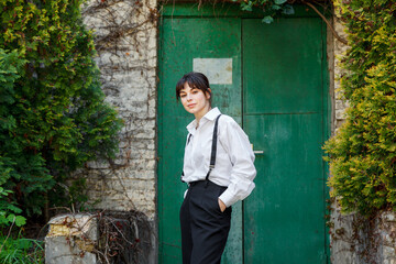 Beautiful girl in a white shirt, in black trousers with suspenders