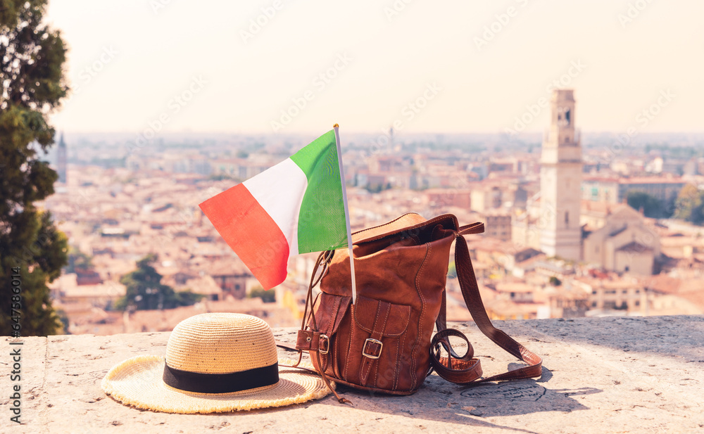 Wall mural sunhat, bag and italian flag with italian city in the background (verona, venetia)- travel,vacation,