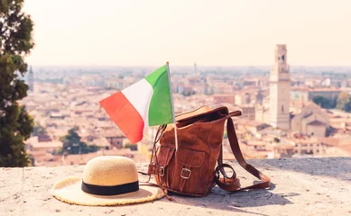 Fotobehang Firenze sunhat, bag and italian flag with italian city in the background (Verona, Venetia)- travel,vacation, tour tourism in Italy concept