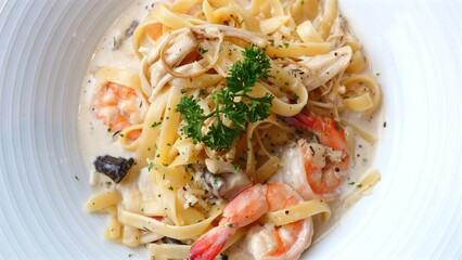 Prawn Fettuccine with Parsley. Italian-style fettuccine with prawns, parsley, and a creamy sauce. Close-up of a gourmet seafood dish.