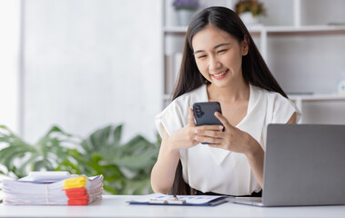Young asian business woman using laptop and using phone note, woman officer hard working communicate with customer and record business employee concept
