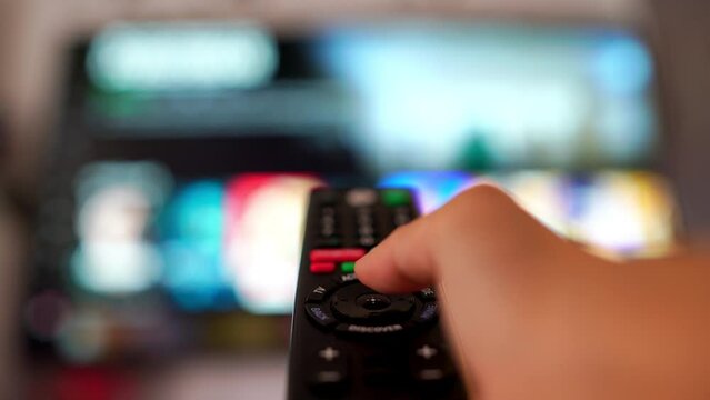 On holidays, people relax at home and watch movies or series. In the living room or living room The person lifts the remote and presses a button to turn on the TV.