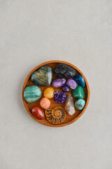 Different healing crystals on a wooden tray, top view
