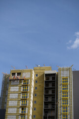 Workers sheathe the outer walls of the building with insulation.Insulation of the facade of the building.Exterior finish