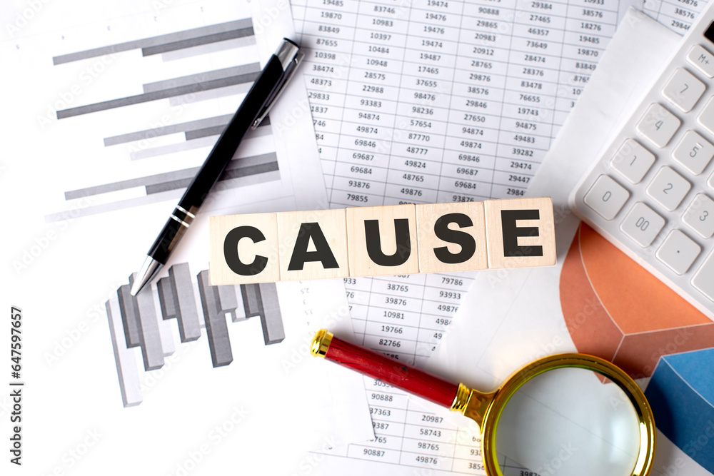 Poster cause text on wooden block on graph background with pen and magnifier