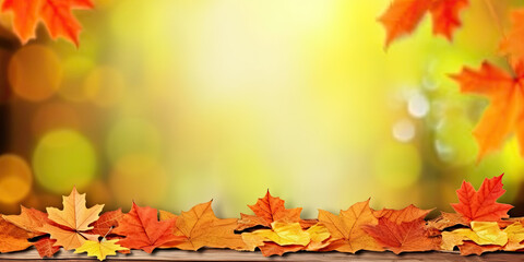 Naklejka na ściany i meble Autumn banner with a frame of beautiful red and yellow leaves on blurred background with bokeh. Just add your text. For any autumn advertising projects.