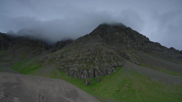 Panning shot showing mountain landscape with road at Strandir, Westfjord during cloudy day