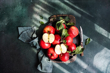 Overhead view of ripe red apples on a table in sunlight