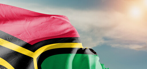 Vanuatu national flag cloth fabric waving on beautiful sky Background.