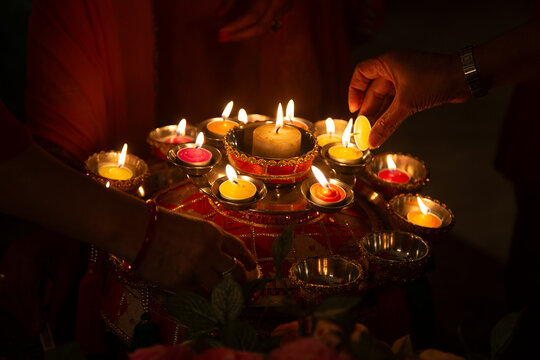 Close-up of a person Lighting candles for a Jago pre-wedding ceremony, New Delhi, India