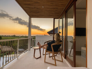 Middle-aged woman relaxing in a chair on a balcony