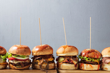 Many different burgers with ingredients on a wood plate. High quality photo - 647608089
