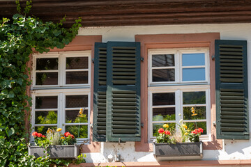 Fototapeta na wymiar window with shutters and summer decoration