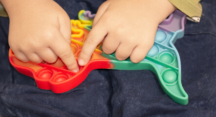 children's hands pressing the buttons of a papit toy