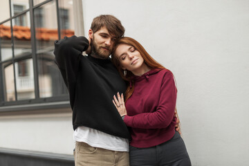 Beautiful fashionable young couple of a brutal handsome hipster man with a beard and a pretty cute...