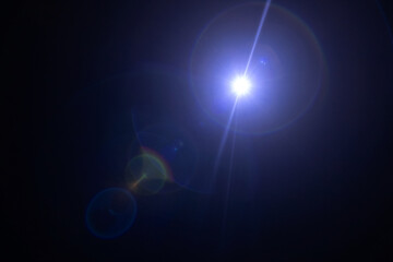Glare on a black background. A camera pointed at the light produces a special flare effect. A ray...