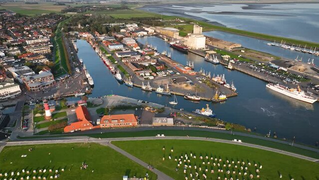 Aerial shot of the town of B&uuml;sum on the German North Sea coast with a lighthouse, ships, and boats moored in the harbor. Landscape of the Wadden Sea by North Sea health spa town B&uuml;sum.