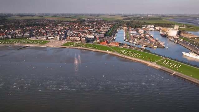 Aerial shot of the town of B&uuml;sum on the German North Sea coast with a lighthouse, ships, and boats moored in the harbor. Landscape of the Wadden Sea by North Sea health spa town B&uuml;sum.