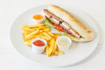 Doner kebab sandwich au steak sur une assiette avec des frites et sauces. 