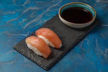 Sushi thon avec une sauce soja dans une ardoise servi par paire. 
