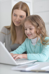 Mother and daughter looking at laptop computer