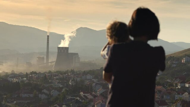 big chimney smoke over the city. Polluted environment. Mother with children watching chimney pollution environment. 