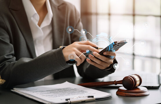 Justice and law concept.Male judge in a courtroom the gavel, working with digital tablet computer on wood table in sun light.