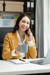 Asian business woman using mobile phone in office.
