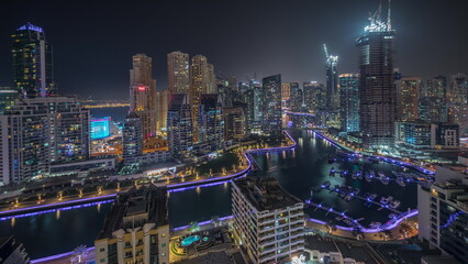 Obraz premium Panorama showing Dubai Marina skyscrapers and JBR district with luxury buildings and resorts aerial night timelapse