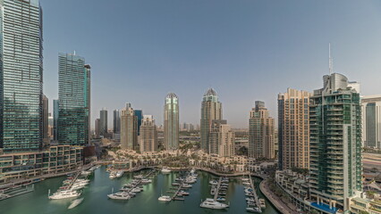 Fototapeta premium Panorama showing Dubai marina tallest skyscrapers and yachts in harbor aerial timelapse.