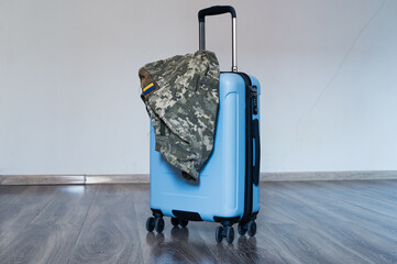 Travel bag with open handle and ukrainian military uniform jacket. Travel, army, mobilization