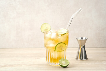 Fototapeta premium Iced tea with lime on a wooden table, refreshing drink 