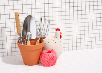 Gardening and ecology concept. Decorative chicken, garden ribbon and tools. Copy space for text.