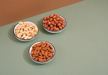 Various nuts lay in plates on the table. Concept of healthy lifestyle. Copy space for text.