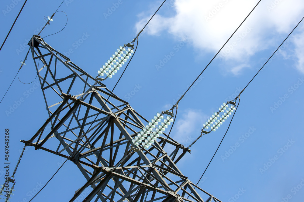 Wall mural high voltage tower with electrical voltage wires isolates close-up against the background of clouds.