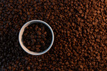 cup of coffee bean on brown cofee background.