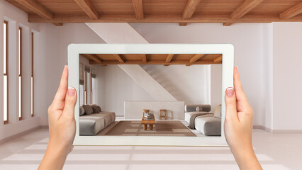 Augmented reality concept. Hand holding tablet with AR application used to simulate furniture and design products in empty wooden interior, minimal living room with staircase