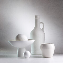 White still life with white dishes and balls on a white background